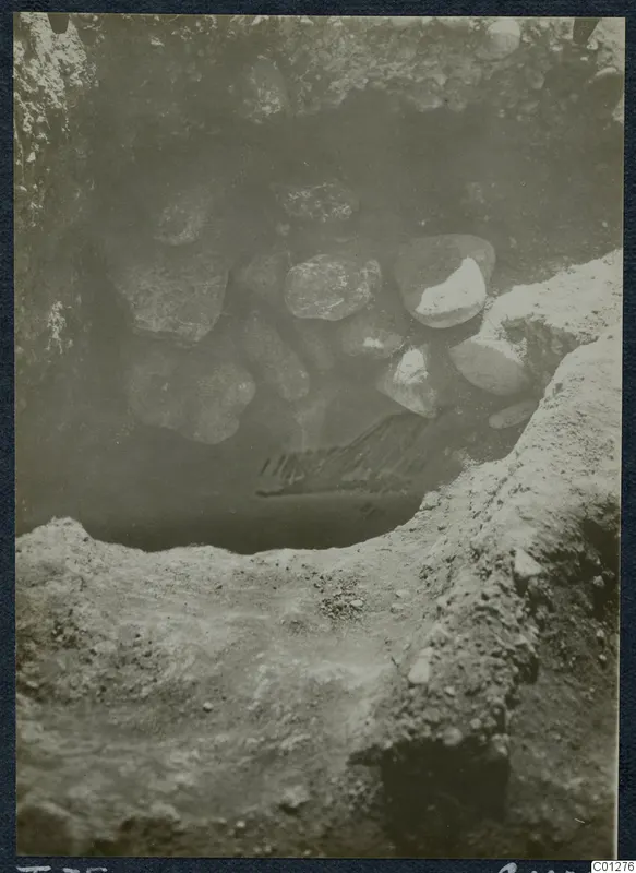Excavation of Tomb 35 at Marion, with loose stones piled in the opening of the tomb cut
