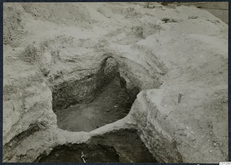 Excavated tomb 47 at Marion, a dug pit with a rounded opening in pale soil walls