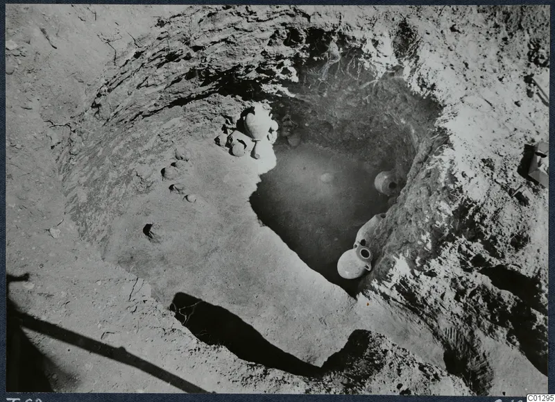 Tomb 62 at Marion during excavation, with pottery vessels lying in the pit and on the ground beside it