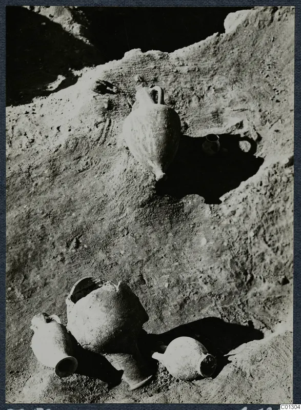 Pottery vessels lying in situ on an excavated earth surface at Marion, Tomb 59