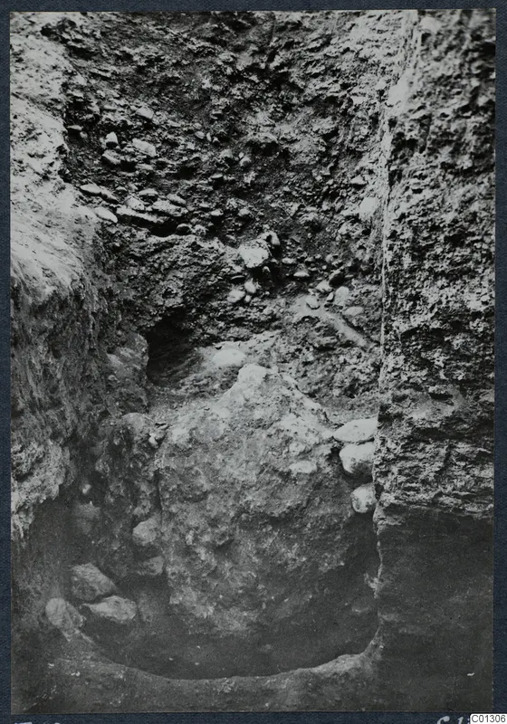 Excavation at Tomb 59 at Marion, with steep soil walls and loose stones in the cut
