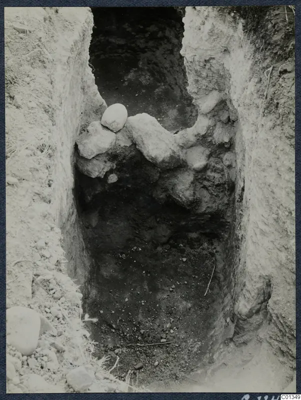 Excavated trench at Marion with rough stones and loose soil on its sides, seen from above.