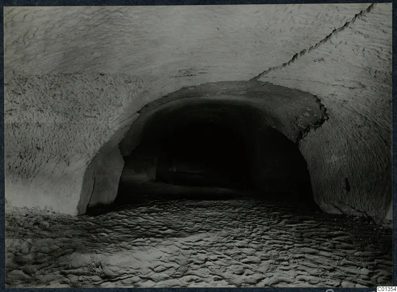 Vaulted rock-cut passage with a dark opening at the far end, on the Karpas peninsula