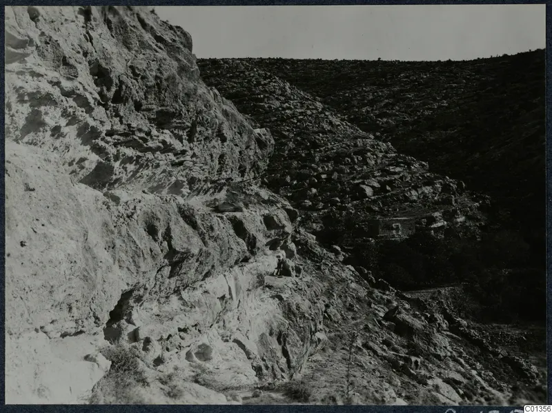 Rocky hillside with stone terraces and a small building in a valley on the Karpas peninsula.