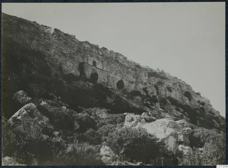 Steep rocky hillside on the Karpas peninsula with a flat-fronted recess and small doorway cut into the cliff face