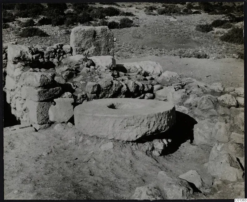 Large round worked stone with a central hollow among rubble walls at Nitovikla, Karpas Peninsula