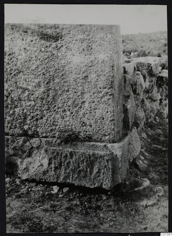 Large squared stone blocks in a wall at Nitovikla, with a low wall running off to the right.