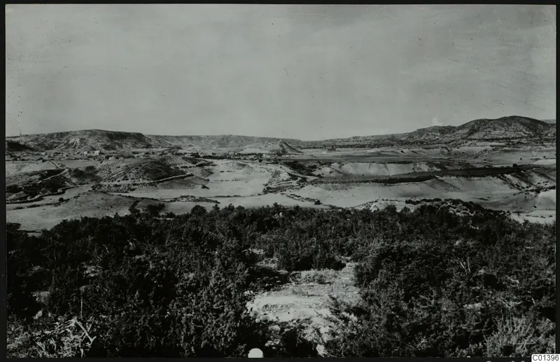 Wide view over Nitovikla on the Karpas Peninsula, with rounded hills and a valley beyond dense scrub in the foreground.