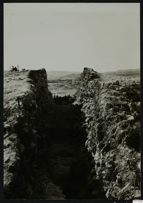 Excavation trench at Nitovikla between high stone-faced banks, with hills and a valley beyond
