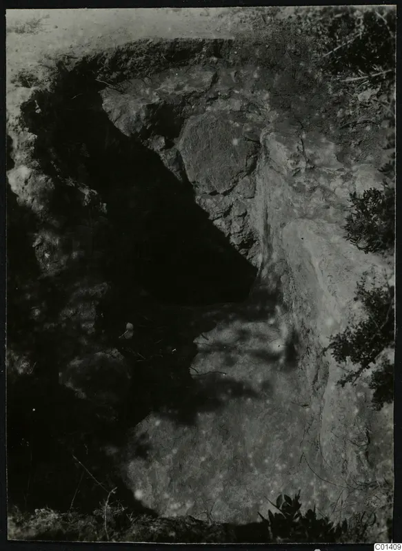Nitovikla, Karpas Peninsula: excavated cutting in rock and soil, with stones and shrubs around it