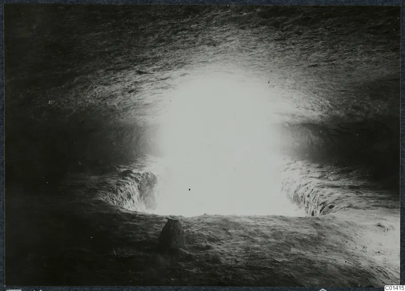 Tomb chamber at Ayios Iakovos during excavation, lit from an opening in the rock-cut wall