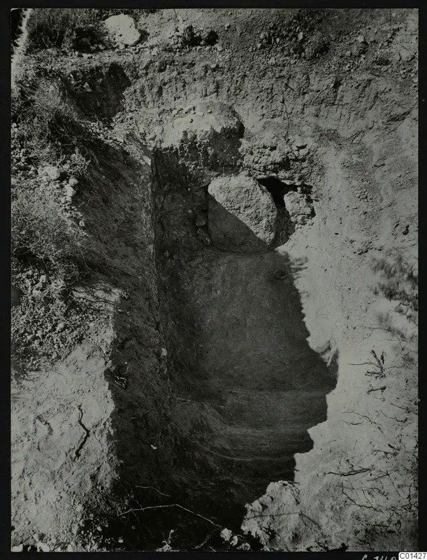Excavated sloping cut in stony ground with a large stone at its upper end, exterior of Tomb 2 at Kountoura Trachonia