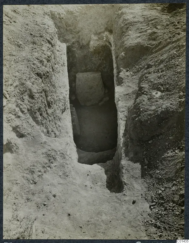 Tomb 10 at Ayios Iakovos: excavated cut leading down to a tomb chamber with a large stone block inside.