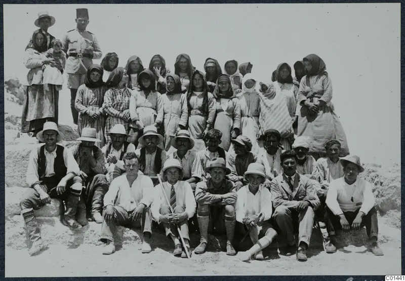 Group photograph of the work force at Vouni on the last day, men and women posed on a rocky slope.