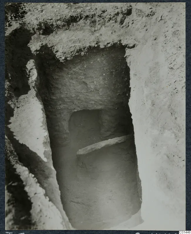 Tomb 5 at Ayios Iakovos during excavation, showing a tomb entrance with a flat stone slab across its lower part.