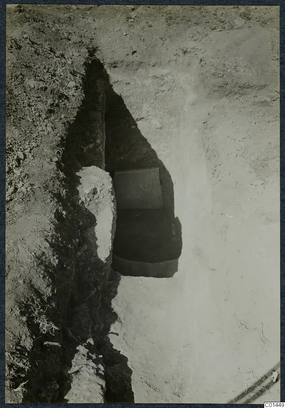 Tomb 4 at Ayios Iakovos: a stone slab in the opening of a tomb chamber in an excavation trench.