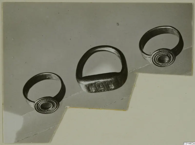Three rings with round and rectangular bezels, photographed together on a grey mount.