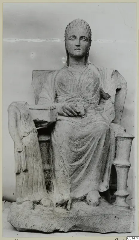 Seated stone statue of a woman on a throne with a rectangular plinth