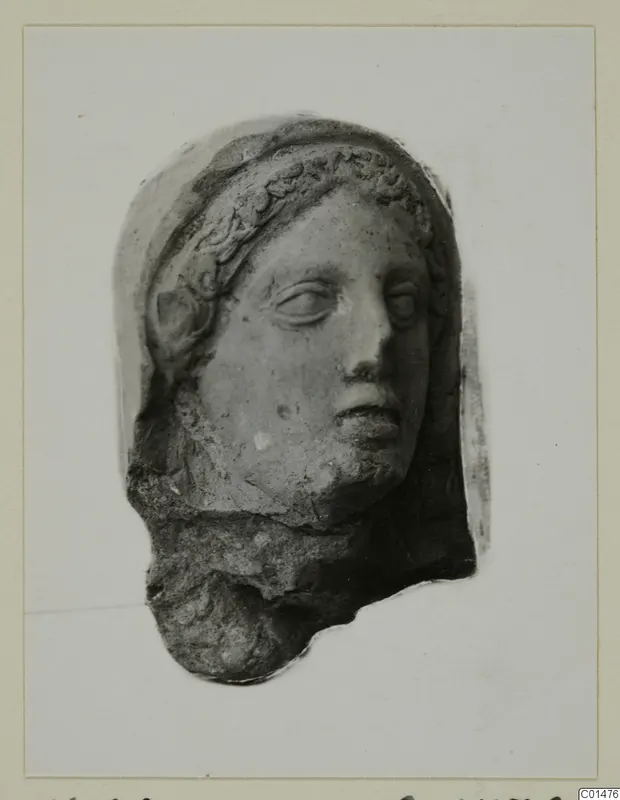 Terracotta head with a wreath or band over the hair and a veil behind it, photographed on a card mount