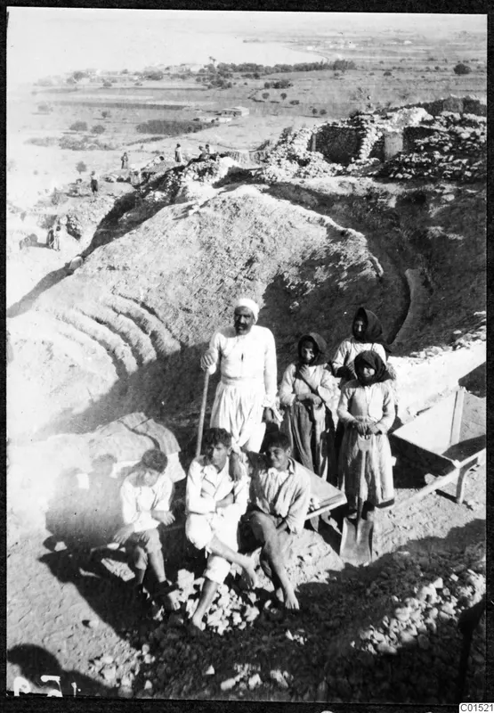 Work group of an older man, three young men and three women at the excavation of Soli, with a wheelbarrow and spoil heap
