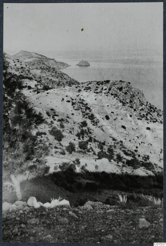 Vouni landscape: dry scrub-covered hills falling to the sea, with a small rocky islet offshore.