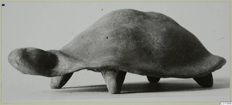 Terracotta figurine of a tortoise with a domed shell, four short legs and the head projecting to the left.