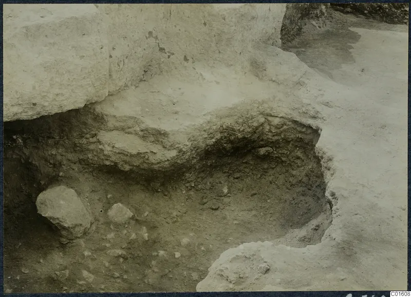 Excavated cutting at Vouni palace with a large stone block and loose stones in the soil