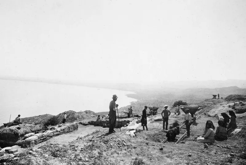 Workers on the eastern slope of the excavation at Vouni, with rail tracks and wagons above the coast.