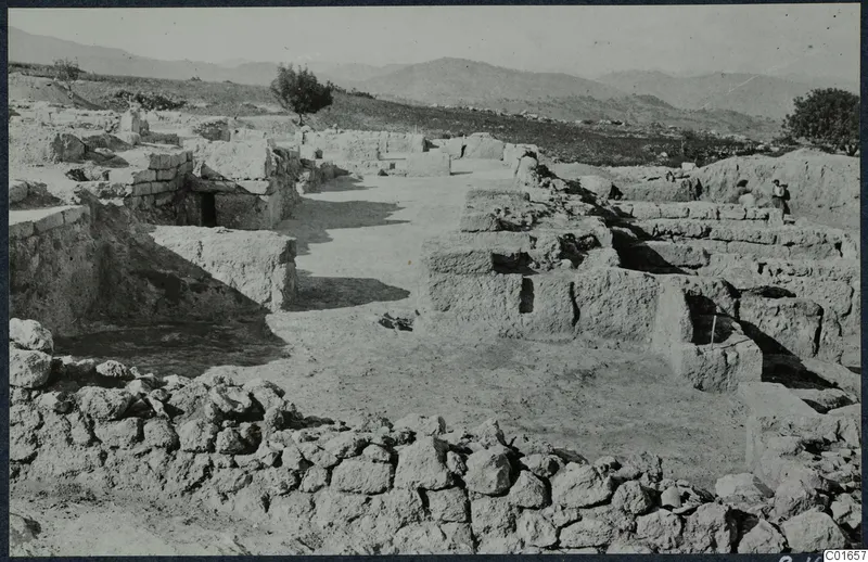 Excavated walls at the palace at Vouni, with a person standing beside a wall at right