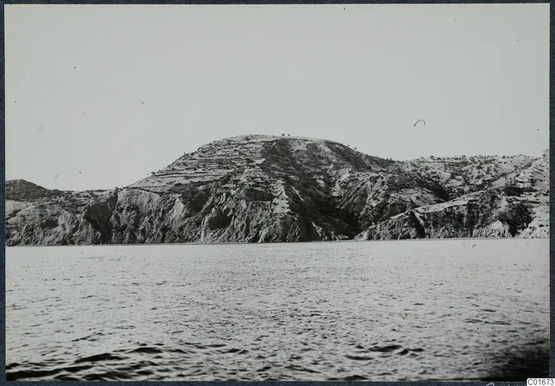 Rocky hill at Vouni rising from the sea, with a few small trees on its crest