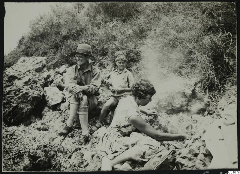The Gjerstad family seated among rocks at Petra tou Limniti, with shrubby hillside behind them.