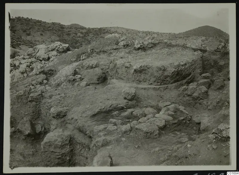 Excavated slope at Petra tou Limniti with large stones and exposed earth below dry hills.