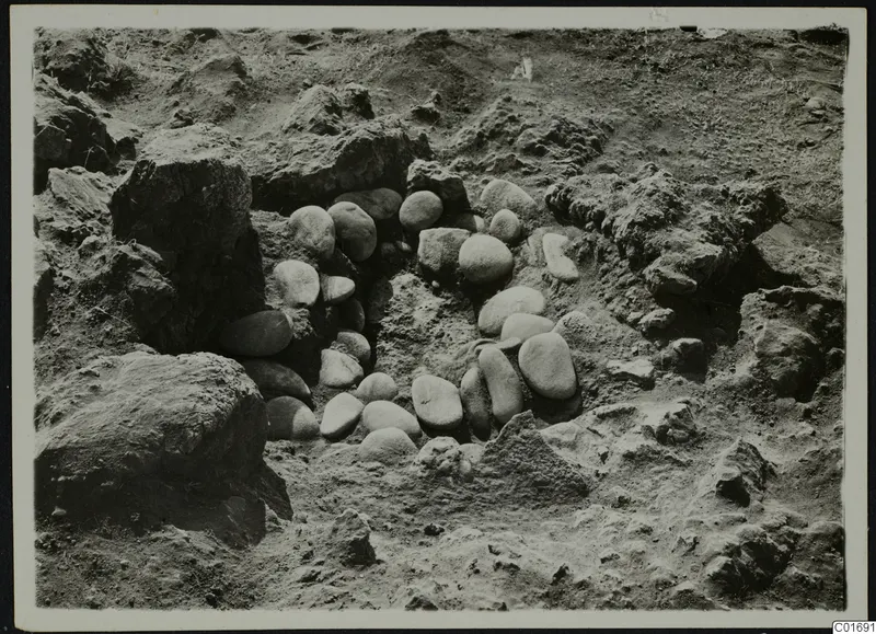 Excavated pit at Petra tou Limniti with a ring of rounded stones set around its edge.
