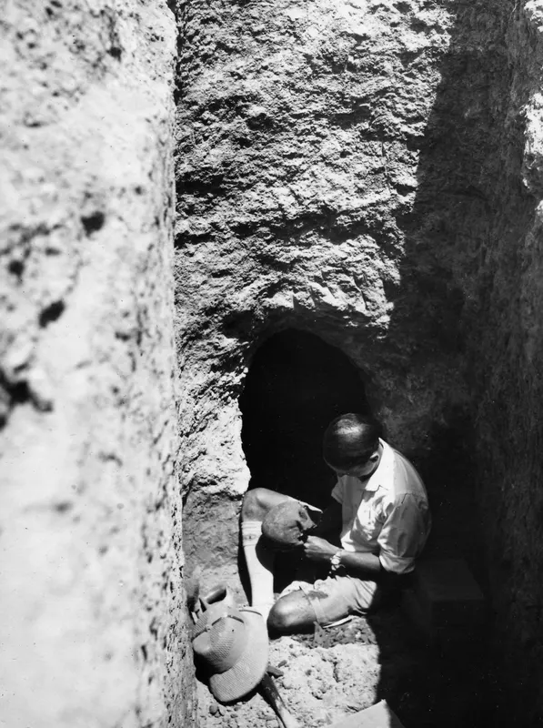 Erik Sjöqvist holding a skull in the dromos leading to Tomb 8 at Ayios Iakovos
