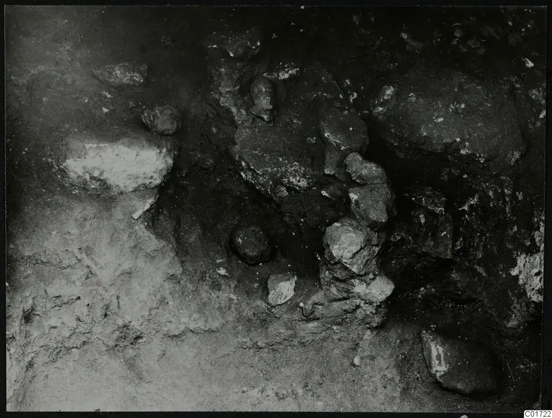 Excavated area at Kition with stones and rounded forms lying in situ in the soil