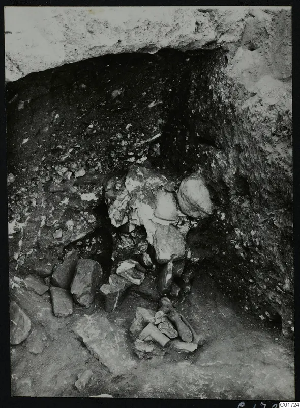 Excavated recess at Kition with stones and broken fragments in situ, with possible bones at the lower centre