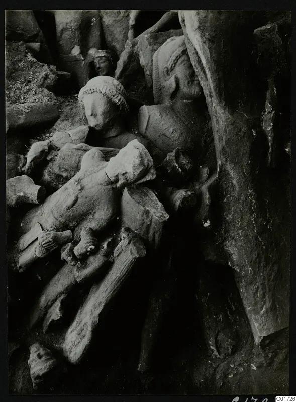 Carved stone sculptures, heads and body fragments piled together in the big deposit in the cult room at Kition