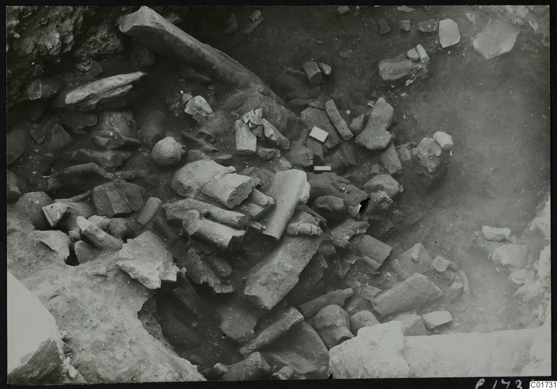Cult room deposit at Kition: broken stone sculpture fragments lying in excavated soil