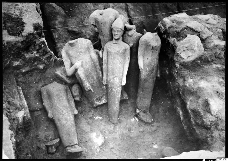 Sculptures in situ in the middle pit at Kition, one central figure wearing a conical cap