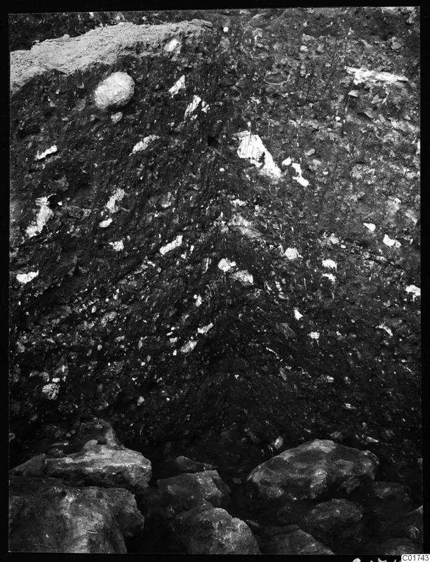 Soil profile in the northeast corner of the cult room at Kition, with large stones at the base