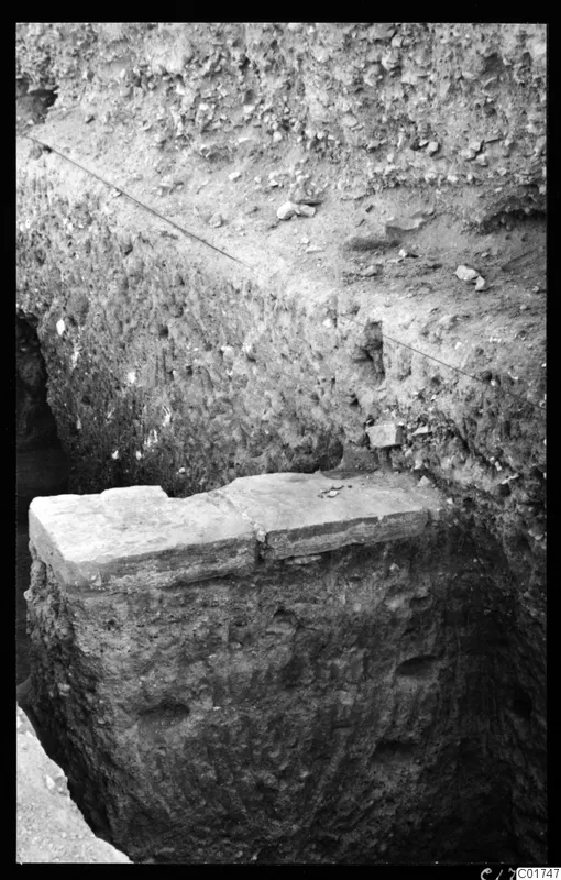 Excavation trench with a large stone block on top of a soil section, at Kition.