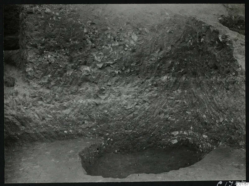 Vertical section of excavated soil at the Bamboula, Kition, with stones in the layers and a hollow cut at its base.