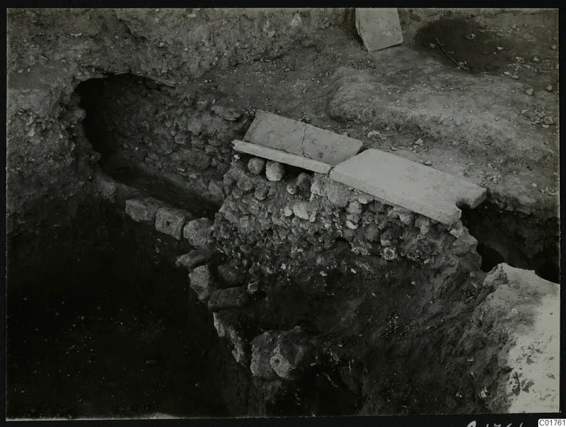 Roman water channel at Kition, built of stone and covered with flat slabs in an excavation trench.