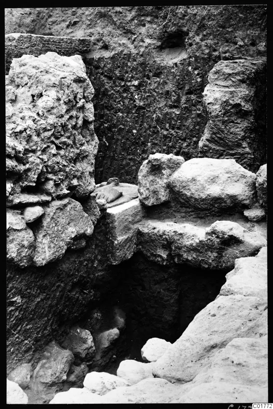 Excavation trench at Kition with large stone blocks and a small carved object on a ledge