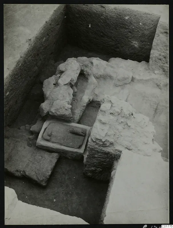 Excavation trench at Kition, Larnaca, with a carved stone slab set in a rectangular stone frame among fallen stones