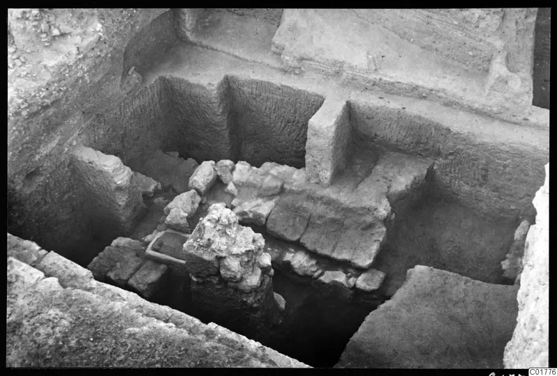 Excavated trench at Kition showing stone walls and a rough stone block in the foreground, seen from the north.