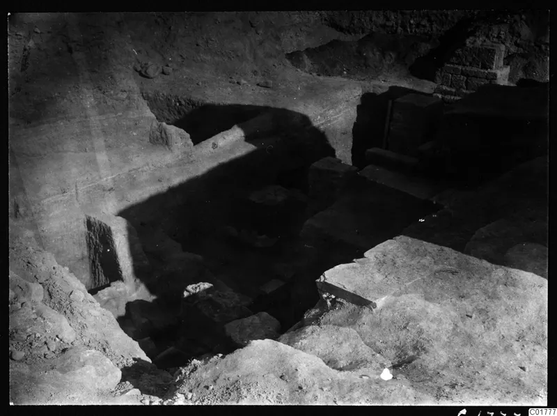 Excavated area at Kition with cut stone blocks, a masonry wall and deep shadows