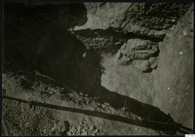 Excavation trench at Kountoura Trachonia with a projecting rock outcrop and stones in the cut face