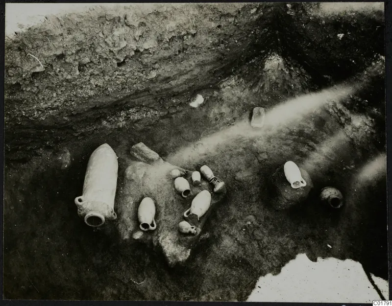 In situ pottery vessels and stones in an excavated trench at Ayia Irini