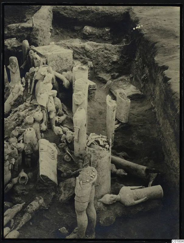 Excavation trench at Ayia Irini with many pale clay figurines and vessels lying in situ among the soil